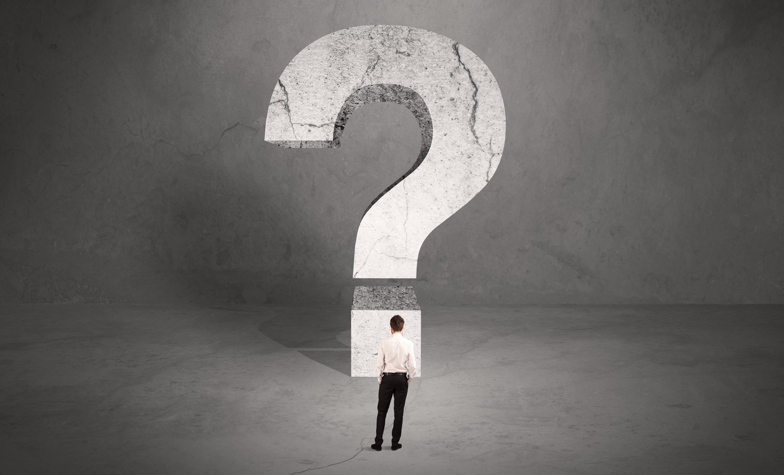 Businessman facing a giant question mark — deciding on a business phone system